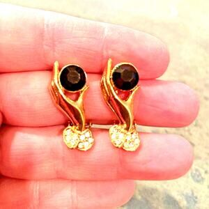 Vintage inspired clip on earrings gold tone hand holding black faceted stone gem